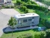 Camping-car installé sur un emplacement stabilisé du camping Les 12 Cols à Hauteville-Lompnes